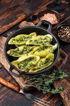 Jumbo shells italian pasta Conchiglioni konkiloni stuffed with beef meat and spinach. Dark Wooden background. Top view.