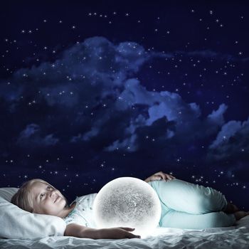 Cute girl sitting in bed and looking at moon planet