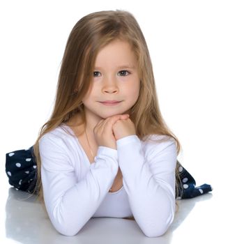 Beautiful little girl lies on the floor on a white background. The concept of a happy childhood, well-being in the family. Isolated.