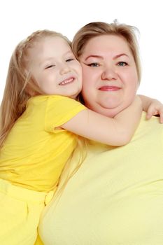 Mom and little daughter plus the size of the model, gently embrace. A woman and her daughter are smiling in a happy manner. Good for the concept of health, happiness, diet, obesity, weight loss.