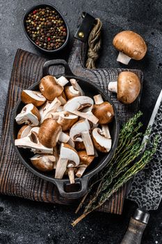 Sliced Raw mushrooms brown champignon. Black background. Top view.