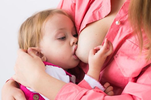 Mother breastfeeding baby in her arms at home. Young woman nursing and feeding baby. Concept of lactation infant.