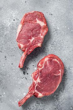 Raw Tomahawk beef (veal) steak on butcher table. Gray background. Top view.