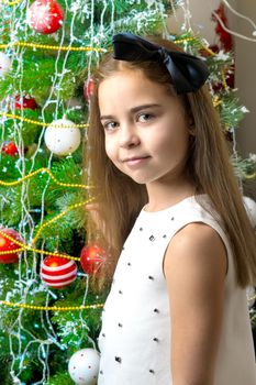 A teenage girl near the New Year tree. Concept Christmas, family holidays.
