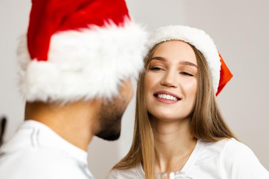 Cheerful attractive happy couple in Santa hats, close up portrait