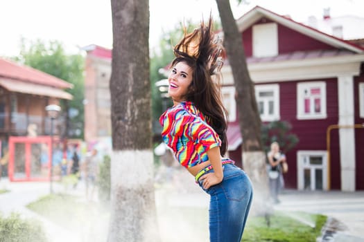 Beautiful attractive young woman having fun and enjoying and dancing in the park on a sunny summer day