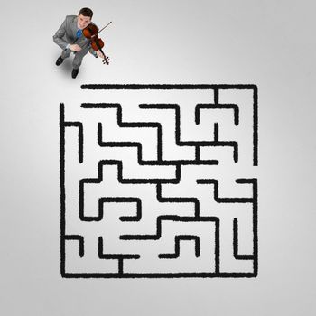Top view of businessman playing violin and drawn labyrinth on floor