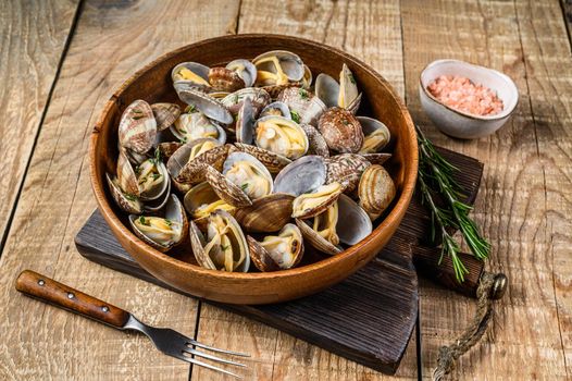 Steamed cooked shells Clams vongole in a wooden plate. wooden background. Top view.