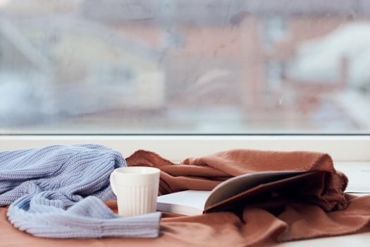 a blanket near the window a cup of coffee book Comfort rest. High quality photo