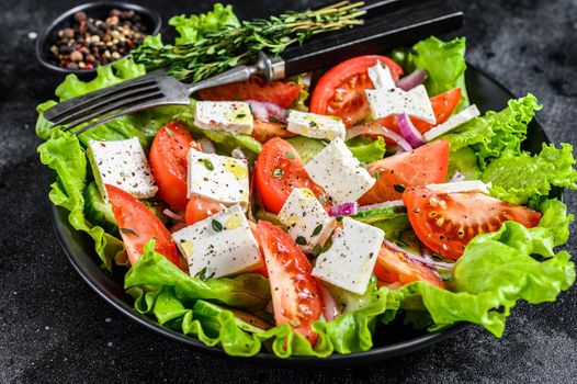 Bowl of ready-to-eat Greek salad. Black background. Top view.