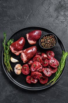Sliced Raw turkey hearts ready for cooking. Black background. Top view. Copy space.