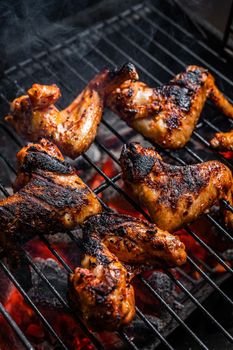 Chicken wings on barbecue, outdoor BBQ grill with fire. Top view.