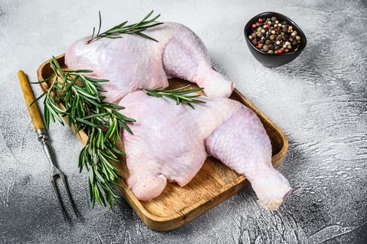 Raw chicken legs on a cutting board. White background. Top view.