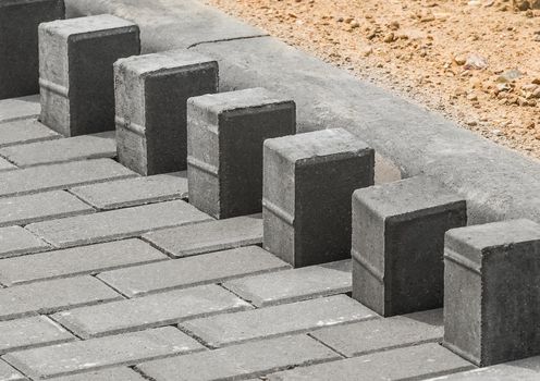Laying floor tile sidewalk urban road or repairing paving stone slabs at a construction site.