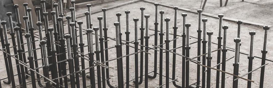 Metal anchor bolts for concrete construction structures, foundation on the background of the reinforcing workshop industrial enterprise.