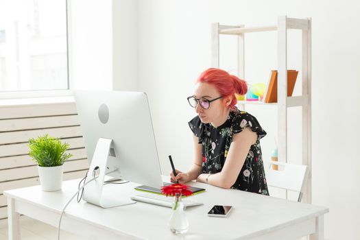 Graphic designer, animator and illustrator concept - young woman with red hair working at the laptop.