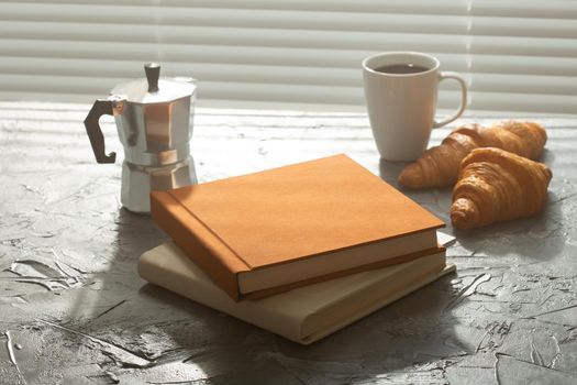 Still life for pleasant morning coffee turk cup and croissants with two books on the table. Lunch break or start the morning