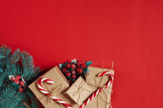 Fir branch and gift box on red background. Top view. Flat lay. Copy space. Still life. Christmas and New year