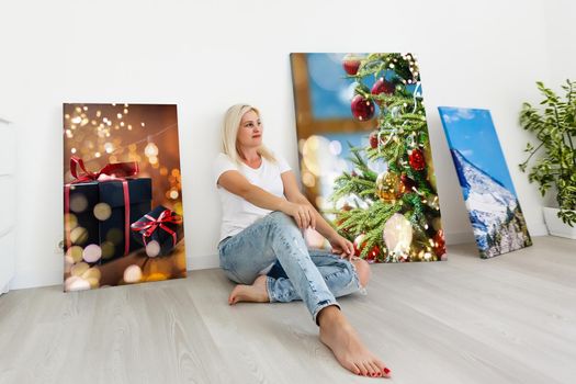 woman holding photo canvas on the background of a interior.