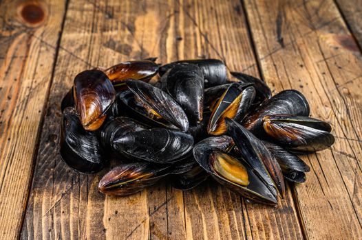 Seafood fresh blue mussels on kitchen table. Black background. Top view.