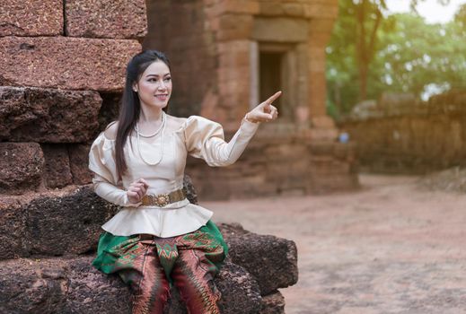 happy beautiful woman inThai traditional dress is pointing