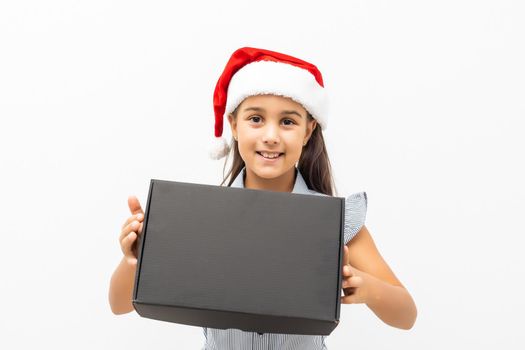 Happy girl holding gift box on white wall background.