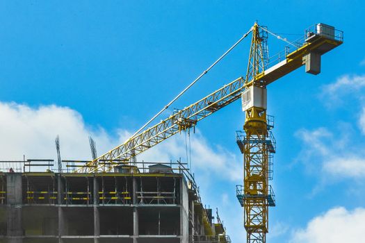 Tower industrial crane on construction site. Building development and work of urban architecture.