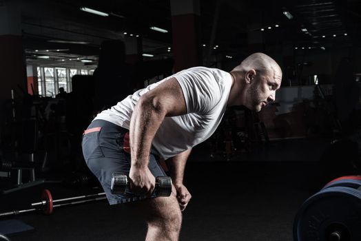 Male bodybuilder engaged with dumbbells in the gym. Healthy lifestyle