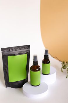 Close up black doy pack and two spray bottles with cosmetic product, green space for your brand. Concept of cluelty free, organic, kosher cream and lotion is great for dry and rough skin.