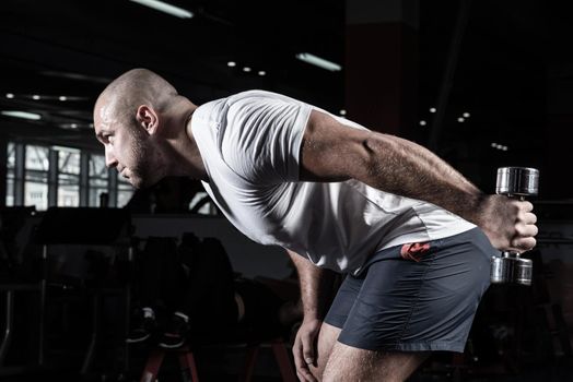 Male bodybuilder engaged with dumbbells in the gym. Healthy lifestyle
