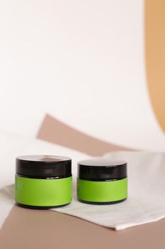 Focus on two jars of facial cosmetic cream with green space for brand. Concept of cluelty free, organic, kosher cream is great for dry and rough skin.