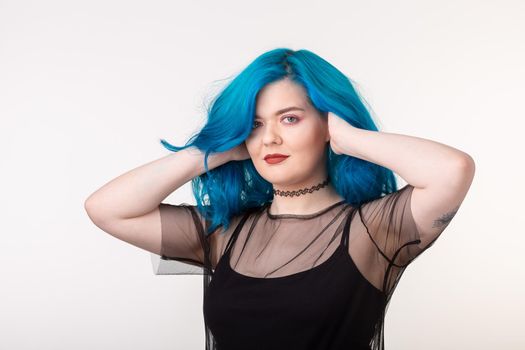 People and fashion concept - Beautiful woman with blue hair posing over white background.