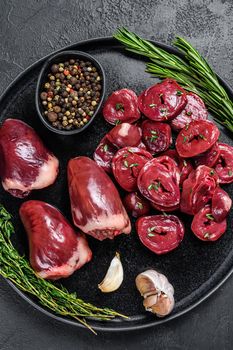 Sliced Raw turkey hearts ready for cooking. Black background. Top view.