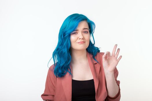 Success pretty woman with blue hair showing hand ok sign.
