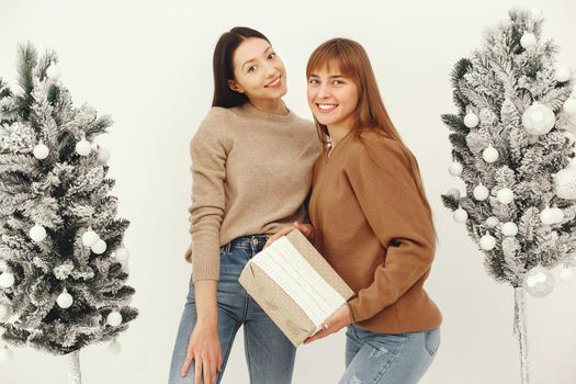 Women with presents. Girl in a brown sweater. Ladies in a studio.