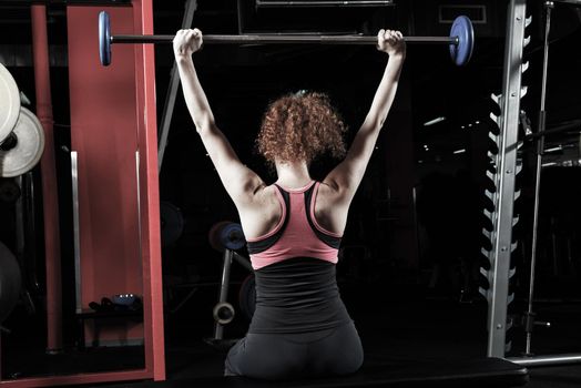 Woman bodybuilder engaged with a barbell in the gym. Healthy lifestyle.