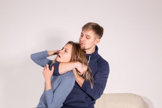 People, abuse and violence concept - aggressive man strangling his wife.