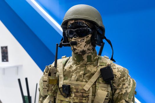 Mannequin in army uniform and equipment. Safety helmet and goggles. Special radio communication device. Modern warfare facilities