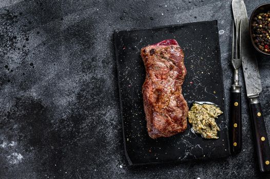 Grilled machete or skirt beef steak. Black background. Top view. Copy space.