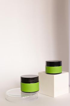 Focus on two jars of facial cosmetic cream with green space for brand in background with copy space. Concept of cluelty free, organic, kosher cream is great for dry and rough skin.