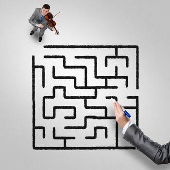 Top view of businessman playing violin and drawn labyrinth on floor