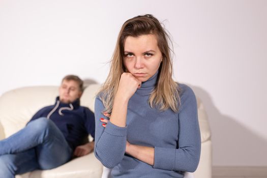 domestic violence, abuse and family concept - crying woman and her husband on the background.