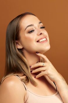 young pretty blond woman with fresh natural makeup posing cheerful on browm background, lifestyle people concept closeup