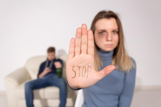 People, domestic violence and abuse concept - Woman shows stop abusing sign over man's background.