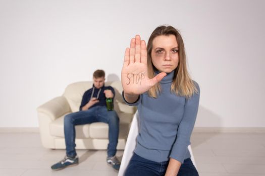 People, domestic violence and abuse concept - Woman shows stop abusing sign over man's background.