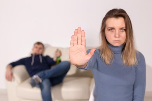 People, domestic violence and abuse concept - Woman shows stop abusing sign over man's background.