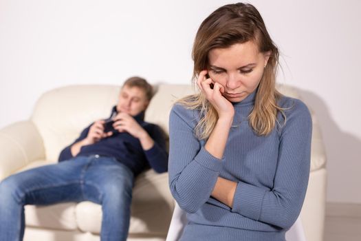 domestic violence, abuse and family concept - crying woman and her husband on the background.