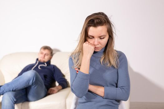 domestic violence, abuse and family concept - crying woman and her husband on the background.