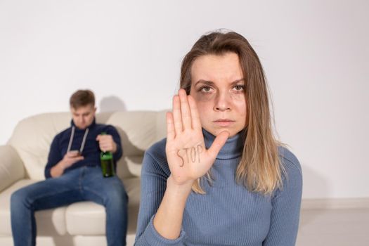 Alcoholism, abuse and problem concept - Sad woman shows stop sign, stop domestic violence.