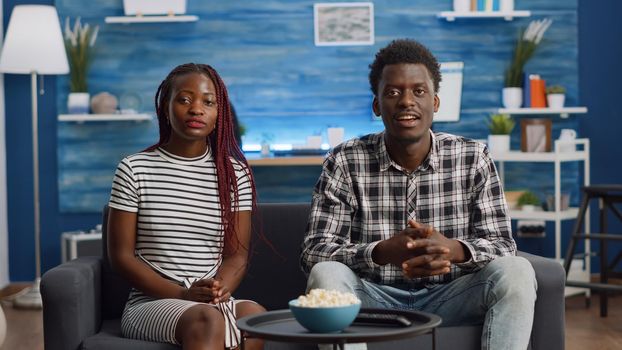 Black couple waving at camera on video call in living room. African american married people talking on online conference for remote communication at home. Partners with technology